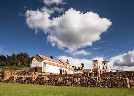 Inca-built stone walls of the Chinchero ruins, overlooked by a colonial-era church.