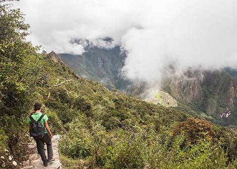 A visitor walking along a stone path on Machu Picchu Mountain, an optional hike for visitors.