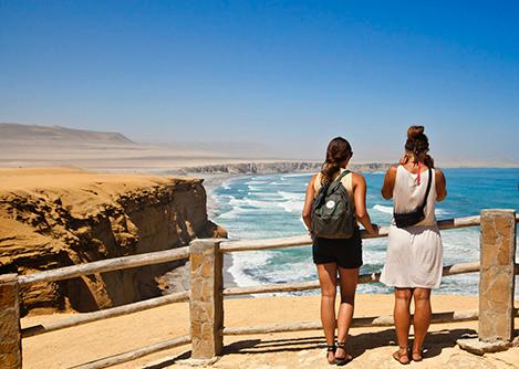 A couple of visitors at a lookout point overlooking a beach in the Paracas National Reserve.