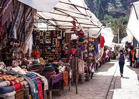 A tourist browsing the famous Pisac Market, the perfect place to buy local handicrafts in Peru.