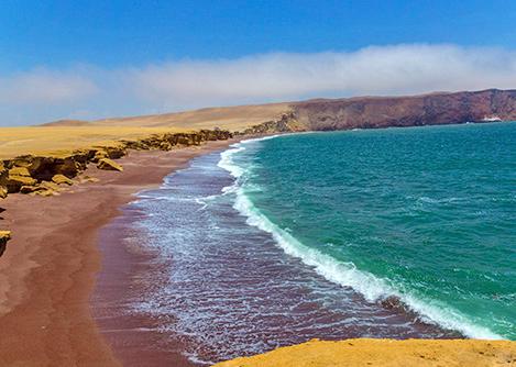 Playa Roja, a famous beach featuring red sand located in the Paracas National Reserve.