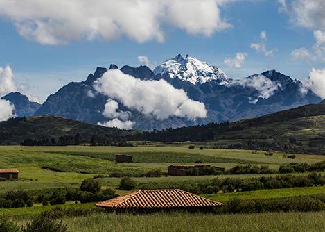 Red roofs dotting an agricultural field overlooked by the Andes Mountains in the Sacred Valley