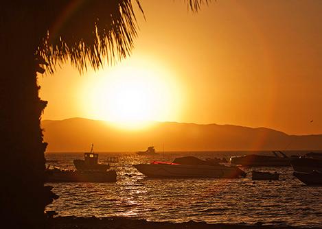 The sun setting over a several boats in the water off the seaside resort town of Paracas.