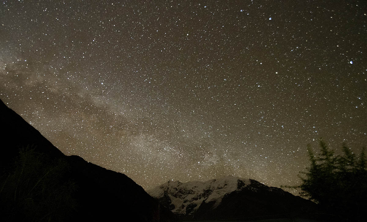 The Milky Way is visible among millions of stars at night over the Andean mountains of the Sacred Valley.